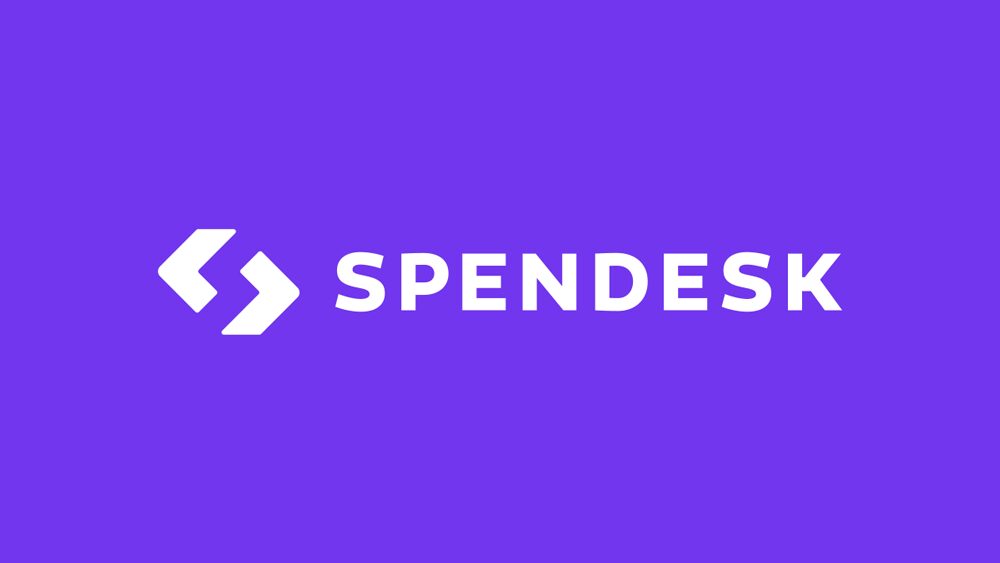 The image features the Spendesk logo, with white stylized arrows followed by the word 